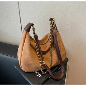 Detailed close-up of brown frosted suede hobo bag with gold metal chain and leather strap