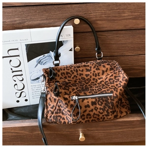 Vue détaillée du sac léopard avec fermeture éclair argentée et poignées en cuir noir