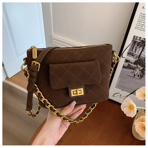Detail of brown quilted suede texture and gold twist lock with engraved brand logo