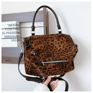 Détail d'un cabas léopard avec bandoulière en cuir et poche avant zippée en métal
