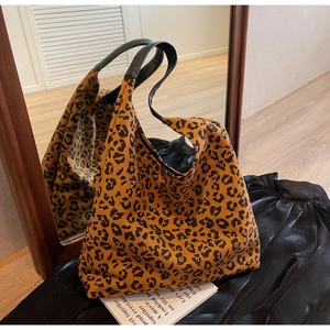 Detailed close-up showing the leopard print pattern and black leather handle of tote bag