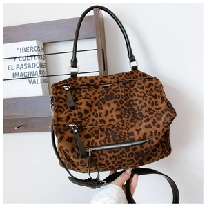 Détail d'un sac cabas léopard avec fermetures éclair argentées et poignées noires arrondies