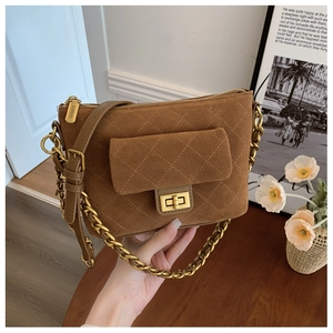 Detail view of brown suede crossbody bag with quilted pattern and gold hardware