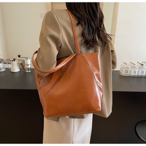 Close-up of caramel vintage tote bag with decorative side metal zipper detail