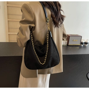 Detail of matte black crescent hobo bag with gold chain strap and adjustable leather handle