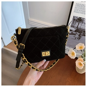 Close-up of quilted diamond pattern bag with gold rotary clasp and chain strap