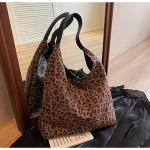 Detail of large leopard print tote bag with black strap reflected in a mirror