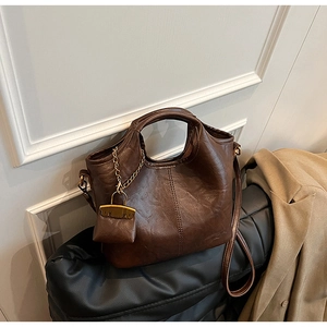 Détail du sac cabas marron foncé vintage avec texture brillante et mini pendentif