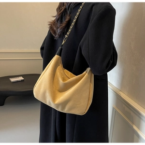 Detail of khaki frosted suede hobo bag with gold metal chain and leather shoulder strap