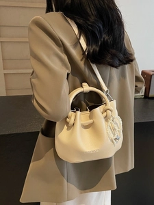 Minimalistische Beuteltasche in Creme mit Tragegriff und eleganter Perlenkette