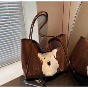 Close-up of a brown glossy tote bag featuring a cute white plush dog patch decoration