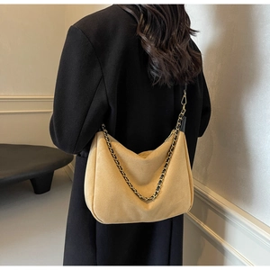 Detail of khaki frosted suede hobo bag featuring decorative black and gold woven chain