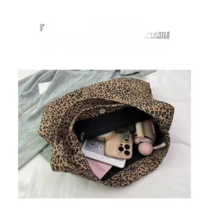 Spacious interior of leopard print canvas tote bag with black lining and zip pocket