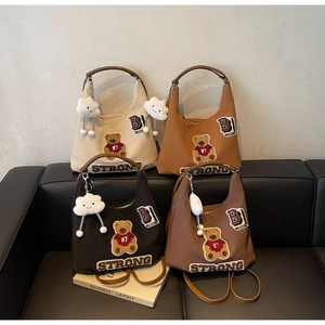 Detailed collection of four large leather tote bags with patches on a black sofa