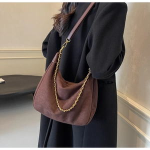 Detail of dark brown matte suede hobo bag with gold metal chain and shoulder strap