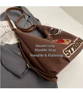 Detailed view of tote bag with STRONG towel embroidery on a casual grey blazer