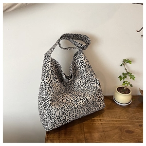 Detail of high-capacity canvas hobo bag featuring black and white leopard print and wide strap