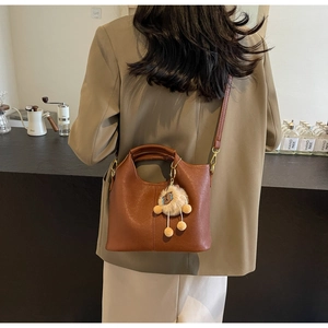 Brown lychee grain handbag with cute plush sheep pendant and adjustable strap detail