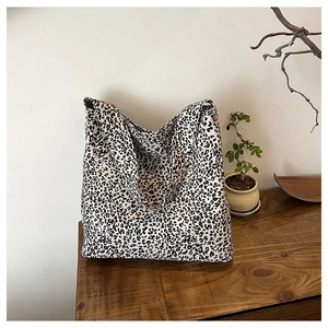 Detail of black and white leopard print tote bag placed on a rustic wooden surface