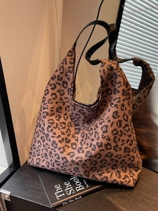 Large leopard print tote bag for women with black handle shown in a stylish setting