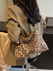 Large leopard print tote bag with leather knot strap and plush charm shown on model