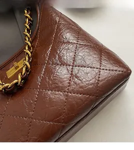 Dettaglio della texture in pelle trapuntata marrone scuro e cuciture degli angoli