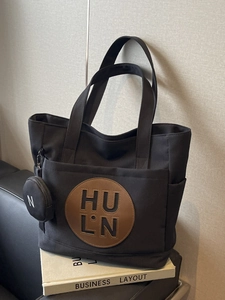 Retro black canvas tote bag with embossed leather logo and small round pouch charm