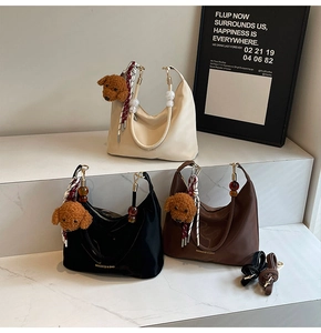 Detalle de bolsos hobo de nailon en tres colores con adorables colgantes de peluche