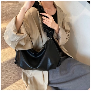Détail de la bandoulière à volants et texture du cuir souple du sac hobo noir