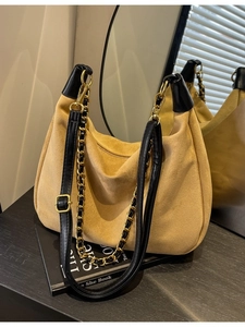 Retro mustard suede hobo shoulder bag with black leather trim and chain detail