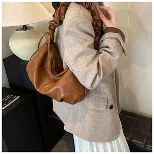 Détail du sac hobo marron vintage avec bandoulière à volants pour un usage quotidien au bureau
