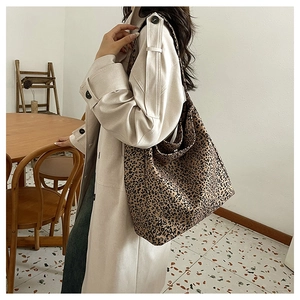 Detailed view of the large capacity leopard print tote bag styled with a beige coat