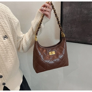 Dettaglio della borsa trapuntata marrone con tracolla a catena oro e chiusura