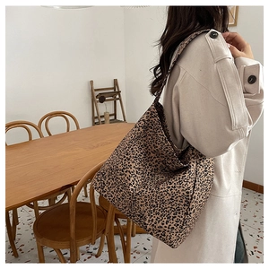 Detailed view of large leopard print canvas tote bag carried by model in casual setting