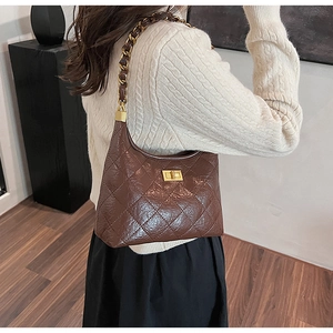 Dettaglio borsa hobo trapuntata marrone scuro con chiusura dorata e tracolla a catena