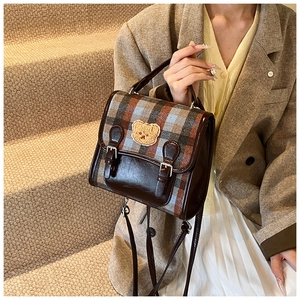 Retro plaid crossbody bag with bear embroidery on stairs shown in a lifestyle shot