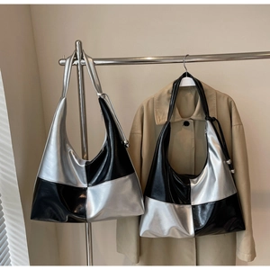 Detail of silver and black contrast color hobo bag with metallic ball pendant on side