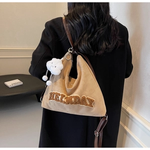 Sac cabas en daim kaki avec lettres en peluche et charme nuage porté par le modèle