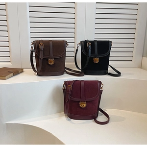Three vintage crossbody bucket bags in brown, black, and wine red with gold bear clasp detail