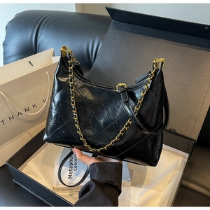 Vue détaillée du sac matelassé noir avec chaîne dorée et cuir ciré à effet vieilli