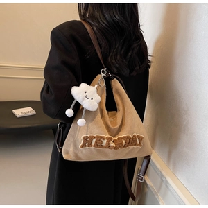 Vue latérale du sac Hobo en daim kaki avec patch en peluche et breloque nuage