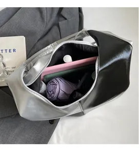 Spacious interior of a metallic silver and black bucket bag with daily essentials