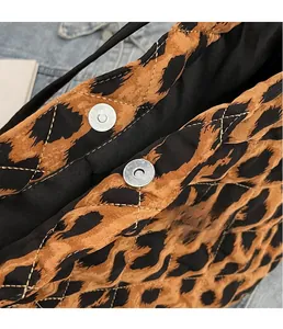 Close-up of the silver magnetic snap closure on the leopard print quilted tote bag