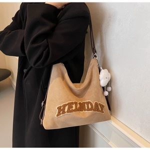 Détail d'un sac cabas en daim marron avec broderie HELDAY et breloque nuage