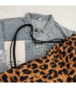 Detailed macro view of leopard print quilted tote bag with black shoulder straps and soft texture