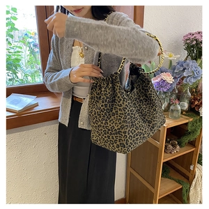 Detail of leopard print tote bag with golden chain strap and pleated edges for women