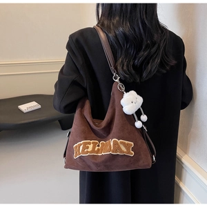 Détail du cabas en daim marron avec broderie KELWAY et breloque nuage en peluche