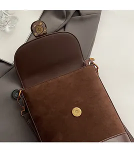 Detail view of brown vintage bucket bag with magnetic closure and contrast leather texture