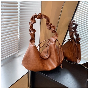 Détail du sac à bandoulière marron caramel avec anse plissée et détails à cordon