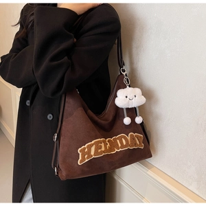 Détail du sac cabas marron foncé avec broderie HEINDAY et pendentif nuage en peluche